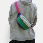 Sac Banane Nylon Ripstop Colorblock Années 90 Sac banane nylon colorblock vert, blanc et violet porté en bandoulière dans le dos, avec sangle rose vif