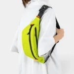 Sac Banane Technique Nylon Ripstop Imperméable Sac banane nylon ripstop jaune fluo porté en bandoulière croisée par une femme au style streetwear décontracté