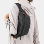 Sac Banane Technique Nylon Ripstop Imperméable Sac banane nylon quadrillé noir porté en bandoulière dans le dos par une femme au style sport