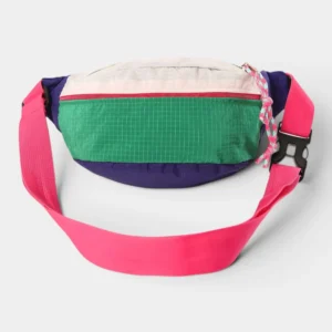 Sac banane nylon ripstop colorblock posé de face, avec une sangle rose vif et une boucle plastique noire