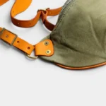 Sac Banane Toile Kaki Militaire Bandoulière Cuir Véritable Sac banane toile kaki en gros plan, avec sangle et rivets en cuir naturel et quincaillerie en laiton doré