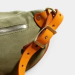 Sac Banane Toile Kaki Militaire Bandoulière Cuir Véritable Sac banane toile kaki, gros plan sur la boucle en laiton doré de la bandoulière en cuir tanné