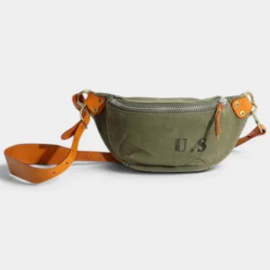Sac banane toile kaki militaire posé de face, avec bandoulière en cuir camel et fermeture éclair argentée