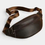 Sac Banane Homme Cuir Grainé Demi-Lune Sac banane en cuir grainé marron foncé posé à plat, vue de trois quarts avec sangle à boucle plastique