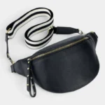 Sac Banane Femme Cuir Grainé Demi-Lune Chic Sac banane en cuir grainé noir posé à plat de face, avec une sangle rayée à fermoirs dorés