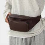 Sac Banane Homme Cuir Grainé Minimaliste Sac banane en cuir grainé marron porté à la taille de face par un homme au style streetwear décontracté