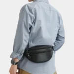 Sac Banane Homme Cuir Grainé Demi-Lune Sac banane en cuir grainé noir porté dans le dos par un homme, vue de dos au style classique