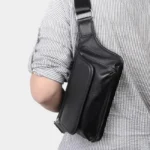 Sac banane cuir motard noir porté sur l'épaule par un homme, vu de dos avec la sangle bien visible
