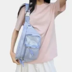 Grand sac banane femme en nylon bleu pastel porté en bandoulière croisée par une femme au style casual-kpop