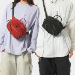 Sac Banane Technique Gorpcore Outdoor Nylon Ripstop Sac banane nylon rouge et noir porté en bandoulière de face par deux femmes au style gorpcore outdoor