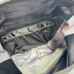 Sac banane moto noir vu de dessus, poche principale ouverte révélant des poches zippées intérieures