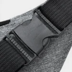 Sac banane en nylon gris, gros plan sur la boucle de fermeture plastique noire de la sangle