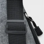 Sac banane en nylon gris, gros plan sur la boucle de réglage de sangle avec fermeture éclair noire