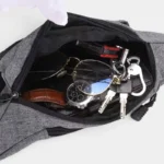 Sac banane en nylon gris, poche principale ouverte vue de dessus révélant des clés et une montre