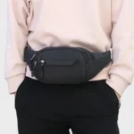 Sac banane nylon noir porté à la taille de face, au style sport casual
