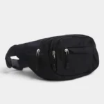 Sac banane nylon noir posé de trois quarts, avec fermetures zippées argentées sur la face avant