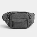 Sac banane en nylon gris chiné posé de face avec plusieurs poches zippées apparentes