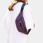 Sac banane en nylon violet porté en bandoulière dans le dos par une femme au style décontracté chic