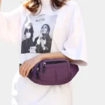 Sac banane nylon violet porté à la taille par une femme au style streetwear décontracté, vue de face