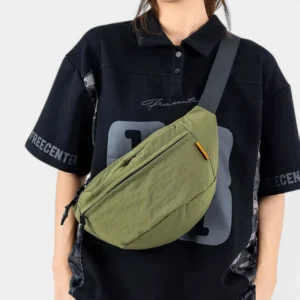 Sac banane nylon froissé vert kaki porté en bandoulière croisée par une femme au style streetwear urbain-décontracté