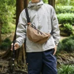 Grand Sac Banane Nylon Ripstop Quadrillé Imperméable Sac banane nylon quadrillé beige porté en bandoulière par un homme de face, au style outdoor randonnée