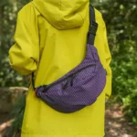 Grand Sac Banane Nylon Ripstop Quadrillé Imperméable Sac banane nylon quadrillé violet porté en bandoulière dans le dos par une personne au style outdoor