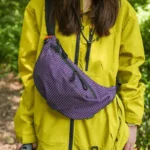 Grand Sac Banane Nylon Ripstop Quadrillé Imperméable Sac banane nylon quadrillé violet porté en bandoulière par une femme de face au style outdoor naturel