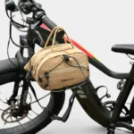 Sac Banane Technique Gorpcore Outdoor Nylon Ripstop Sac banane nylon beige sable fixé sur le cadre d'un vélo, vu de face avec cordon élastique croisé