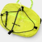 Sac Banane Technique Gorpcore Outdoor Nylon Ripstop Sac banane outdoor nylon jaune fluo vu de dessus, avec des gouttes d'eau sur la surface imperméable
