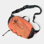 Sac banane randonnée en nylon orange quadrillé, posé à plat avec une sangle réglable noire