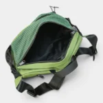 Grand sac banane randonnée en nylon vert, vu de dessus avec la poche principale ouverte révélant une poche zippée intérieure