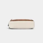 Sac banane en simili cuir écru et camel, vu de dessous sur fond neutre