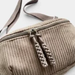 Grand Sac Banane Femme Velours Côtelé Demi-Lune Sac banane en velours côtelé beige, gros plan sur les deux tirettes tressées de la fermeture éclair argentée