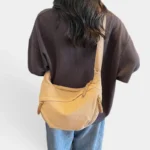 Sac Banane XXL Femme Velours Côtelé Sac banane en velours côtelé camel porté en bandoulière de dos par une femme au style casual-chic