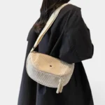 Grand Sac Banane Femme Velours Côtelé Demi-Lune Sac banane en velours côtelé bicolore beige et gris porté en bandoulière par une femme au style chic casual
