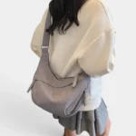 Sac Banane XXL Femme Velours Côtelé Sac banane XXL en velours côtelé gris porté en bandoulière de dos par une femme au style cozy chic
