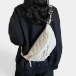 Grand Sac Banane Femme Velours Côtelé Matelassé Grand sac banane en velours côtelé matelassé blanc porté dans le dos par une femme au style casual-chic