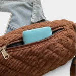 Grand Sac Banane Femme Velours Côtelé Matelassé Sac banane en velours côtelé matelassé marron, gros plan sur la poche avant ouverte avec un portefeuille bleu turquoise
