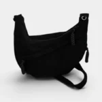 Sac Banane XXL Femme Velours Côtelé Sac banane en velours côtelé noir posé de côté, poche avant ouverte révélant l'intérieur