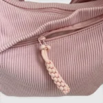 Sac Banane XXL Femme Velours Côtelé Sac banane en velours côtelé rose poudré, gros plan sur la poche avant ouverte avec son curseur de fermeture éclair tressé
