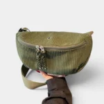 Grand Sac Banane Femme Velours Côtelé Demi-Lune Sac banane en velours côtelé vert kaki tenu à la main, présenté de face avec sa sangle réglable assortie