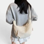 Sac Banane XXL Femme Velours Côtelé Sac banane XXL en velours côtelé beige porté en bandoulière de dos par une femme au style casual-chic