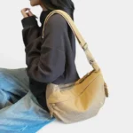 Sac Banane XXL Femme Velours Côtelé Sac banane XXL en velours côtelé beige porté sur l'épaule par une femme au style casual chic