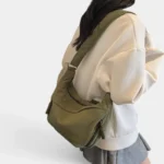 Sac Banane XXL Femme Velours Côtelé Sac banane XXL en velours côtelé vert kaki porté en bandoulière par une femme au style casual-chic