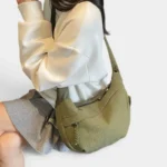 Sac Banane XXL Femme Velours Côtelé Sac banane XXL en velours côtelé vert kaki porté sur l'épaule par une femme au style casual chic