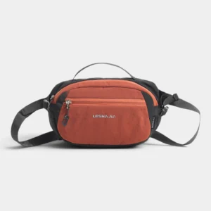 Sac banane bicolore en nylon orange et noir, vu de face, poignée sur le dessus et sangle réglable.
