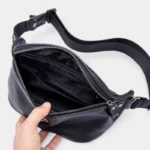 Sac banane en cuir noir ouvert de dessus avec poche zippée intérieure et séparation centrale