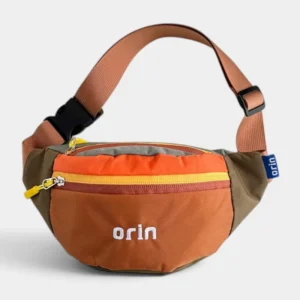 Sac banane enfant en nylon orange terracotta à empiècements kaki, suspendu et vu de trois-quarts.