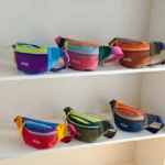 Sac banane enfant en nylon, les six coloris alignés sur deux étagères et vus de face.