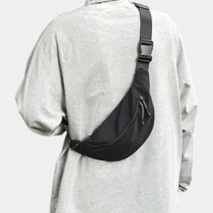 Sac banane nylon satiné noir porté en bandoulière ramené dans le dos avec boucle clip assortie